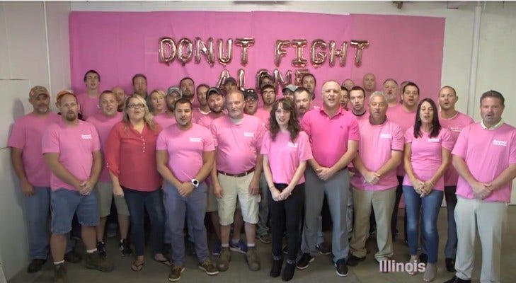 group of people all wearing pink shirts