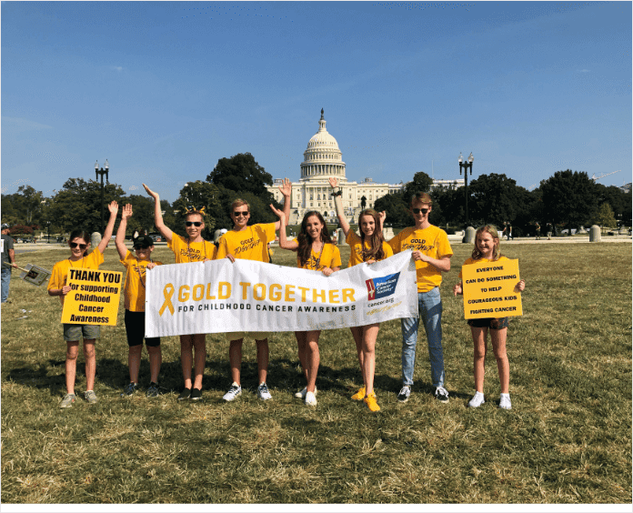 group of white youth holding Gold Together banner outside Capital building
