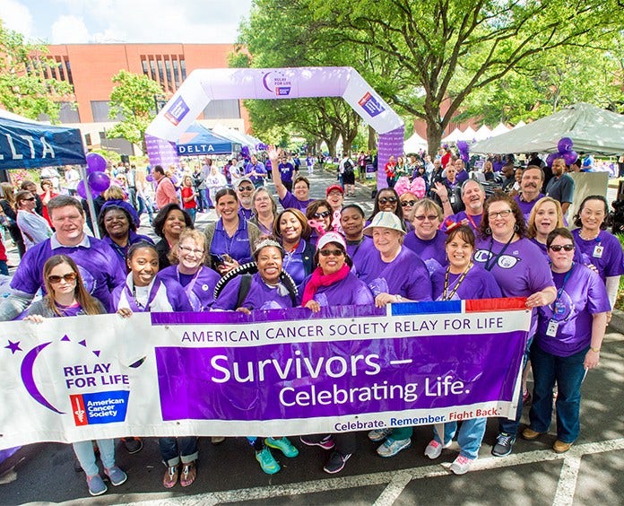 Cancer survivors holding up a "Survivors Celebrating Life" banner at the Delta Relay For Life event