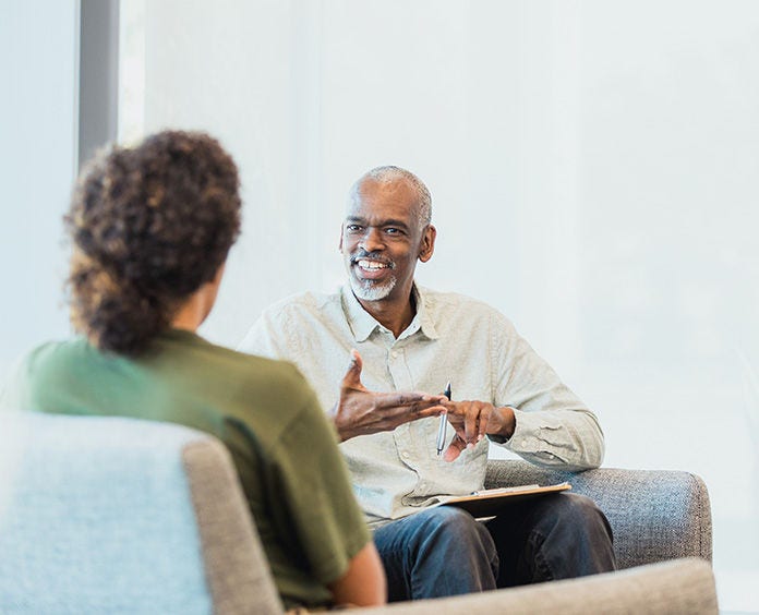 black man talking to white woman in waiting room area