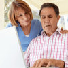 smiling senior couple talk with their doctor 