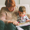 белая бабушка читает книгу со своим внуком 
