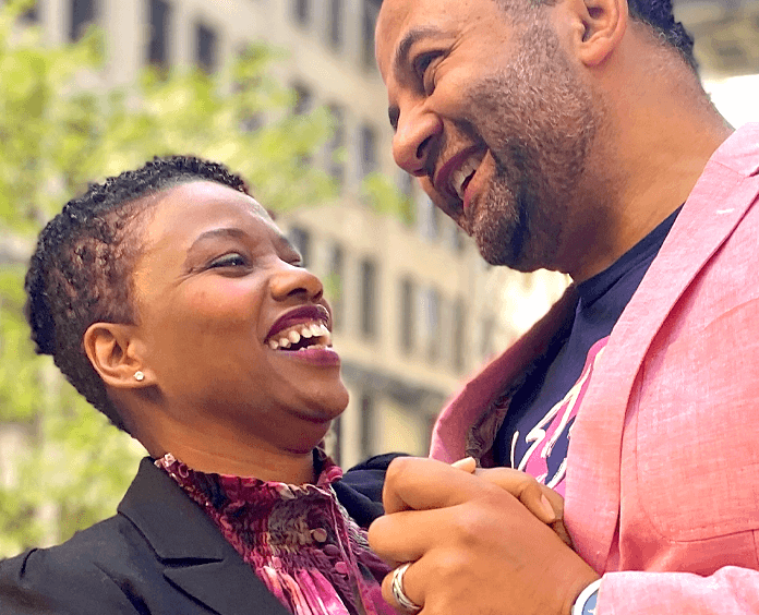 Мужчина и женщина, улыбающиеся снизу, одетые в розовое