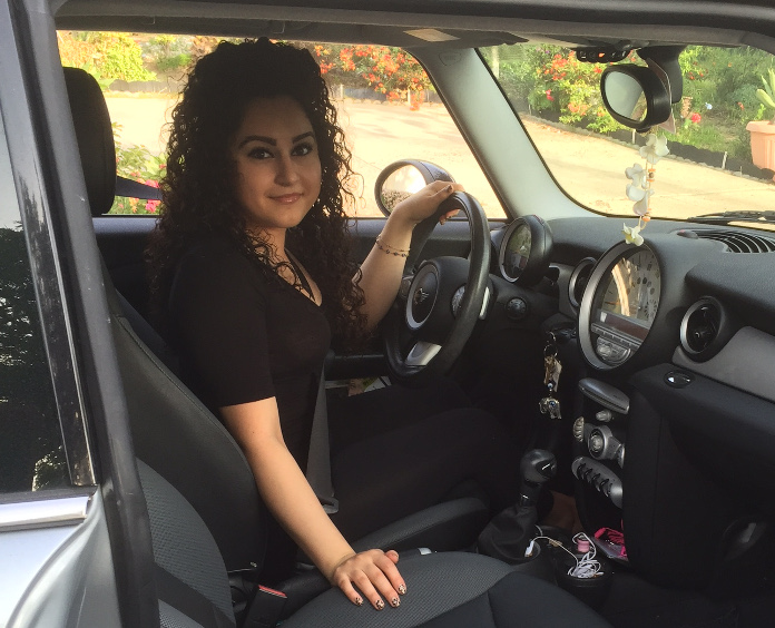 smiling college age Road to Recovery driver sitting behind the wheel