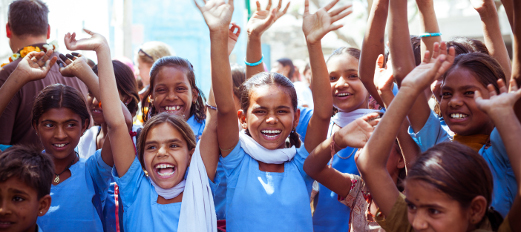 group of happy young Indian girls with their hands in air