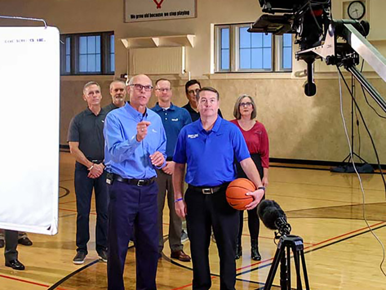 group of people filming a video in a gym