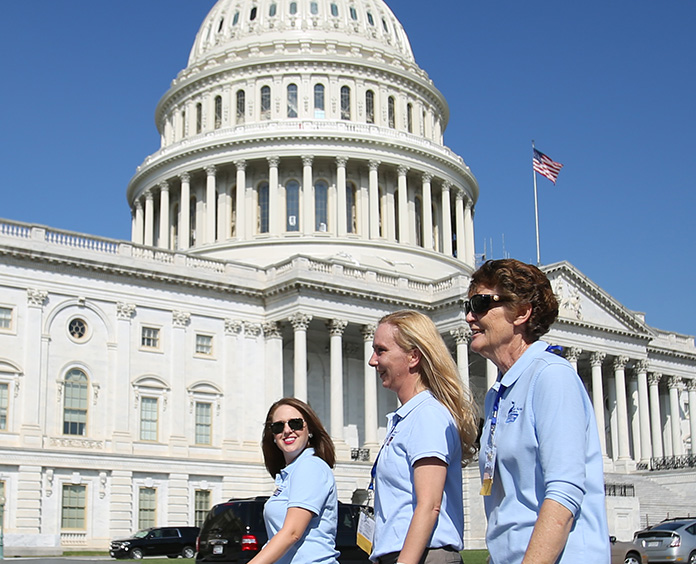 three lobby day advocates walking together in from of a capital building