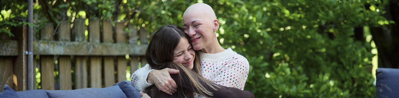 Woman hugs child in backyard