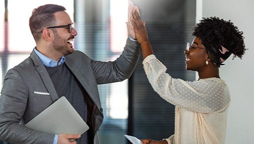 white man and black woman high fiving at office space