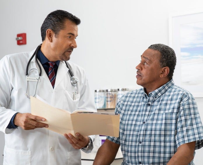 doctor talking to male patient in exam room