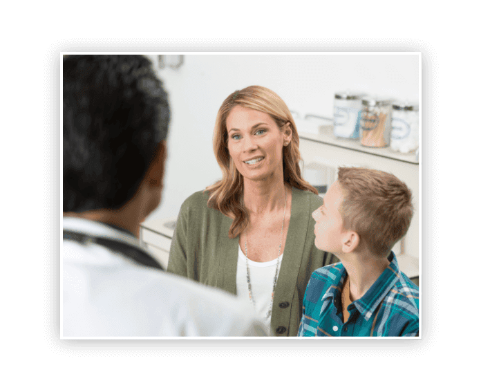 caucasian mother and son talking with doctor