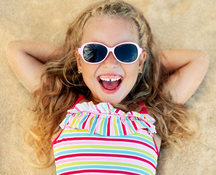 Girl smiling wearing swimsuit and sunglasses