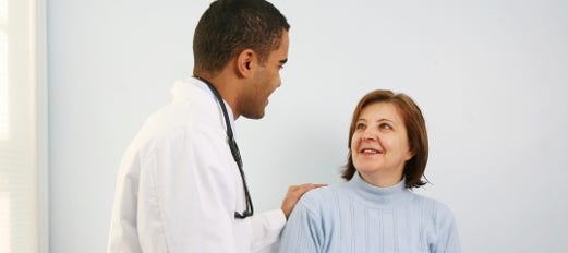 doctor comforts female patient in office
