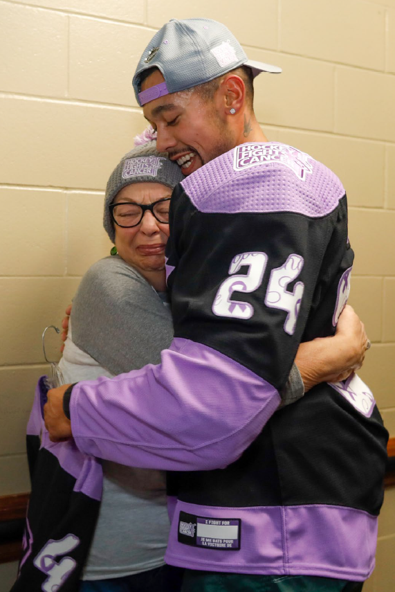 hockey player hugging older woman
