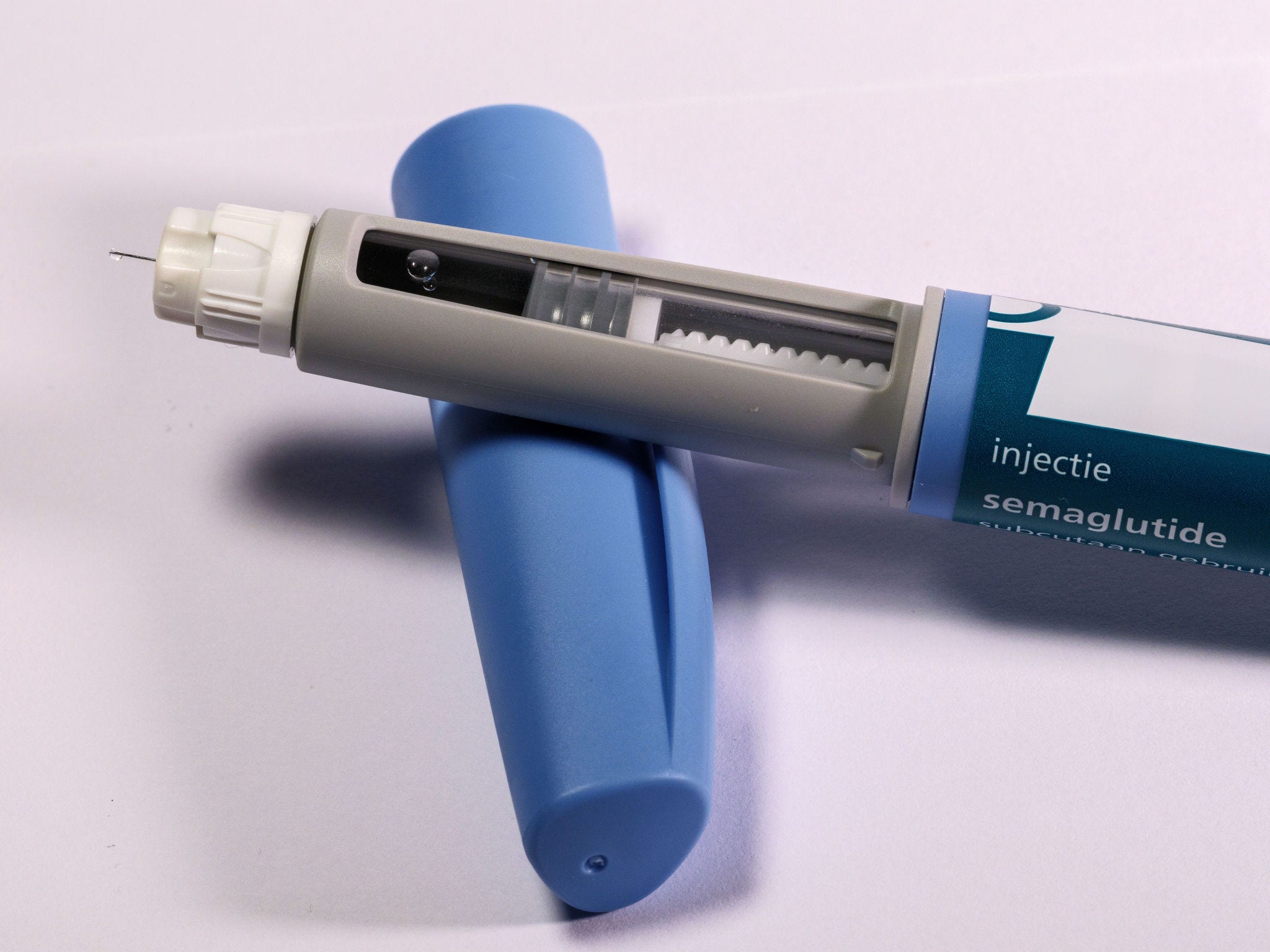 blue semaglutide shot sitting on blue cover/cape