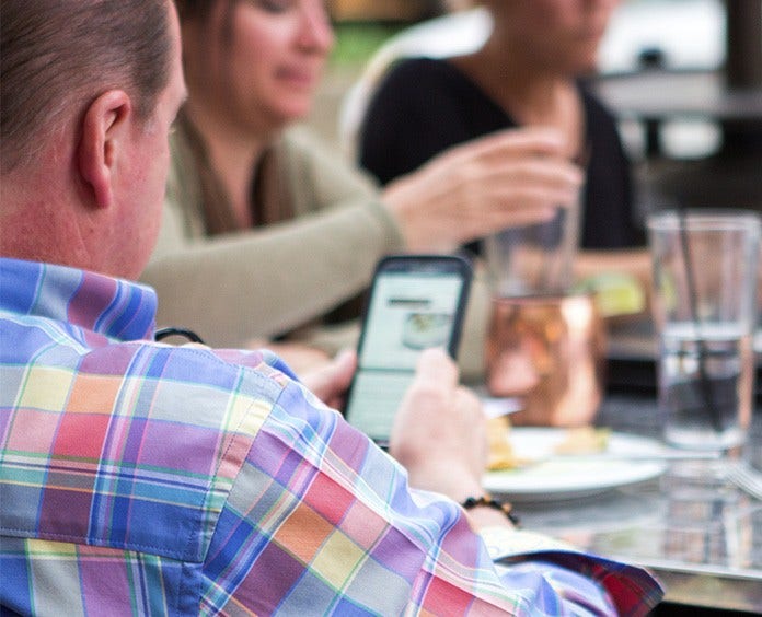 Man looking at phone in restaurant