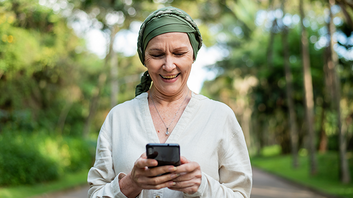 woman wearing head scarf looking down at cell phone
