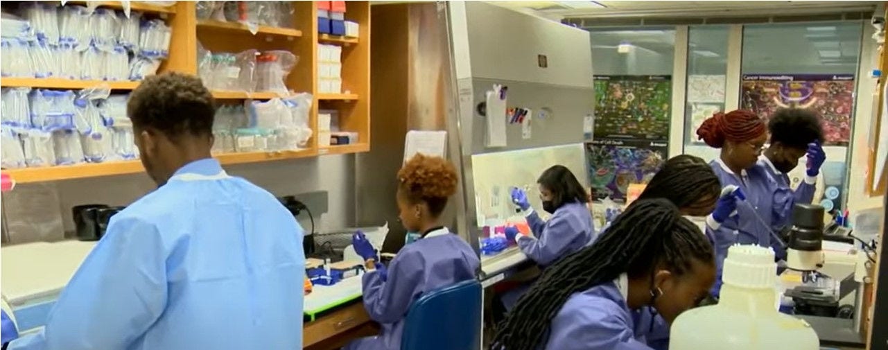 lab filled on both sides with students in blue lab coats