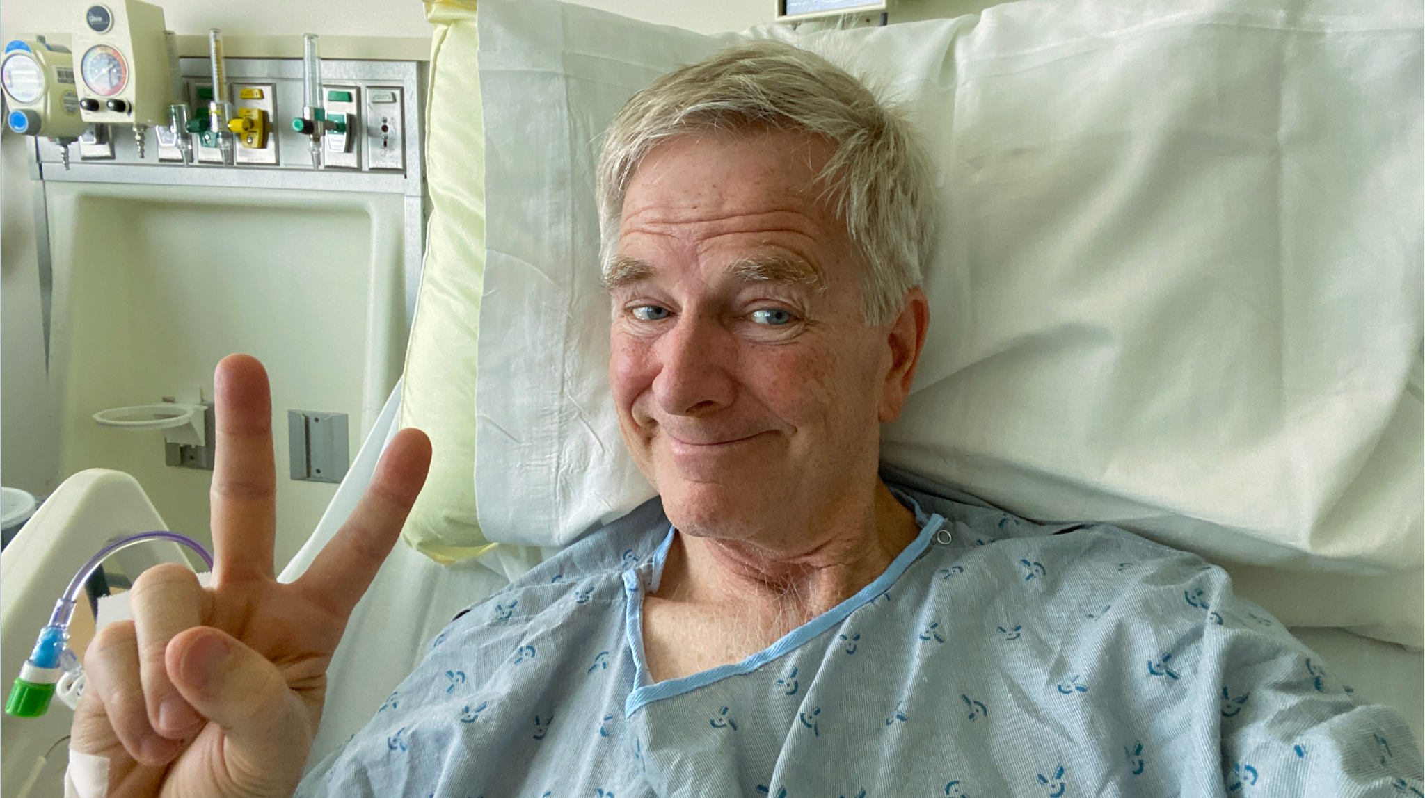 Rick Steves in hospital bed, smiling