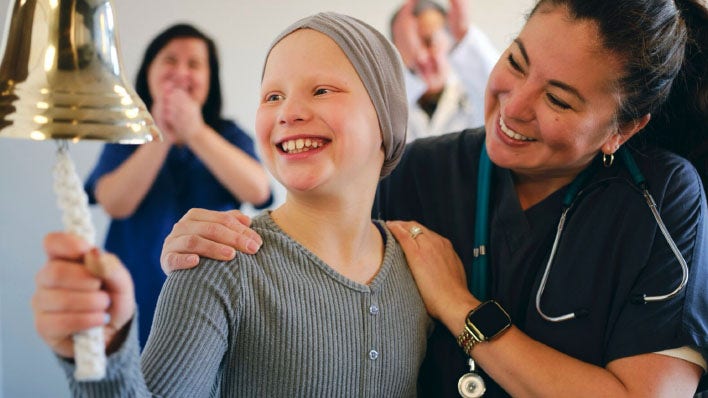Niño tocando la campana, celebrando el fin del tratamiento contra el cáncer.
