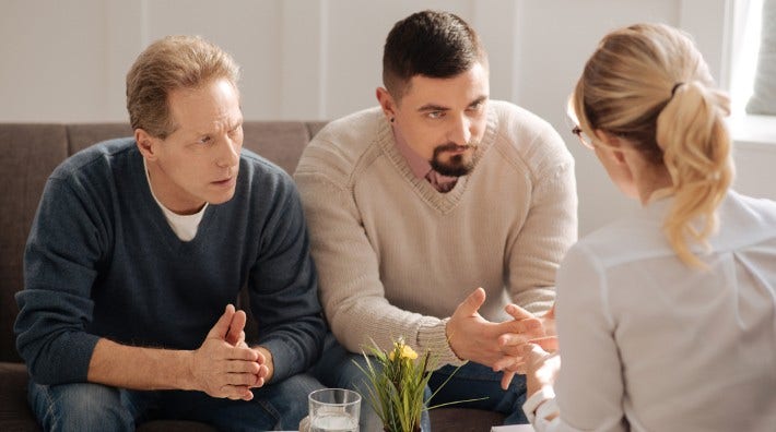 concerned gay couple listening to doctor