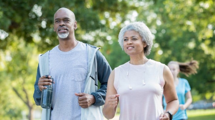 couple walking for exercise in park