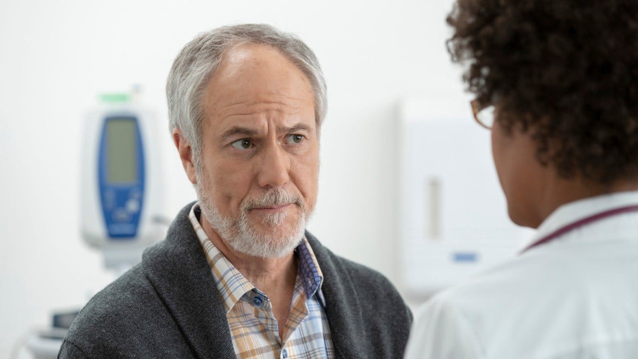 concerned man listening to his doctor in exam room