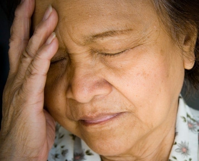 woman grimaces with headache pain