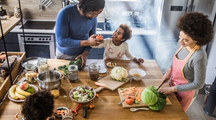 High angle view of happy African American family preparing meal together in the kitchen