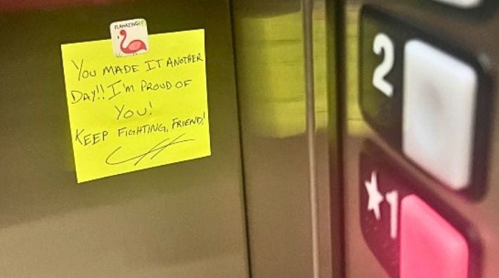 A yellow sticky note displayed inside an elevator, featuring words of encouragement.