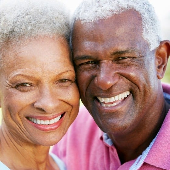 Outdoor portrait of happy senior couple smiling to camera