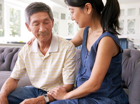 adult daughter with arm around her father