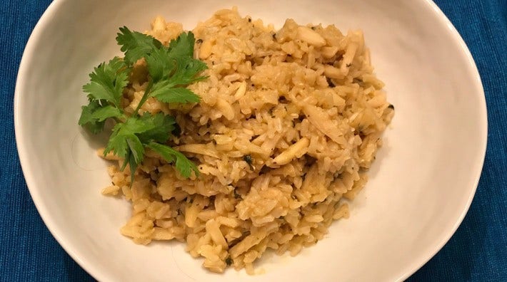 plate on table containing the dish "Brown Rice with Almonds" from the ACS cookbook "Maya's Secrets"