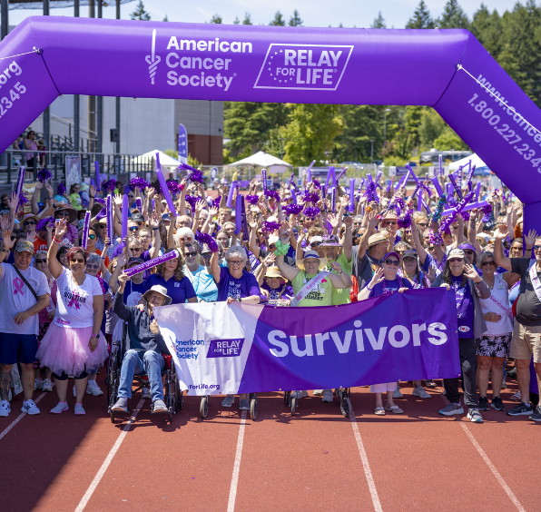 Relay for Life survivors holding purple banner.