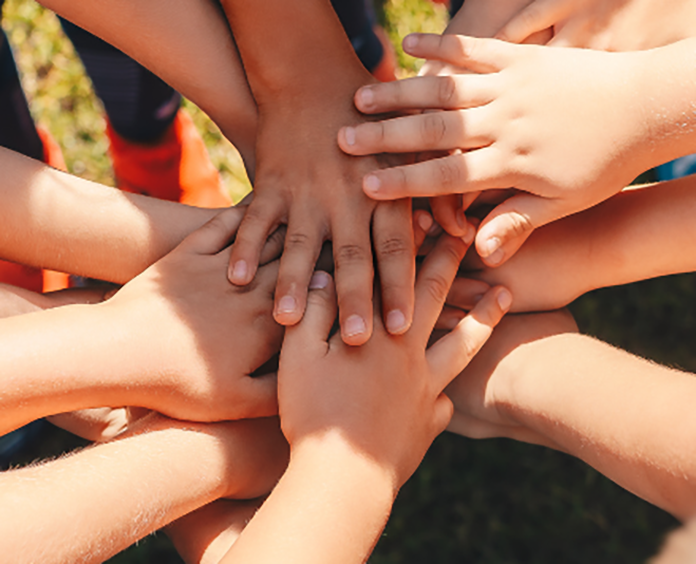 group of young hands stacked in a huddle