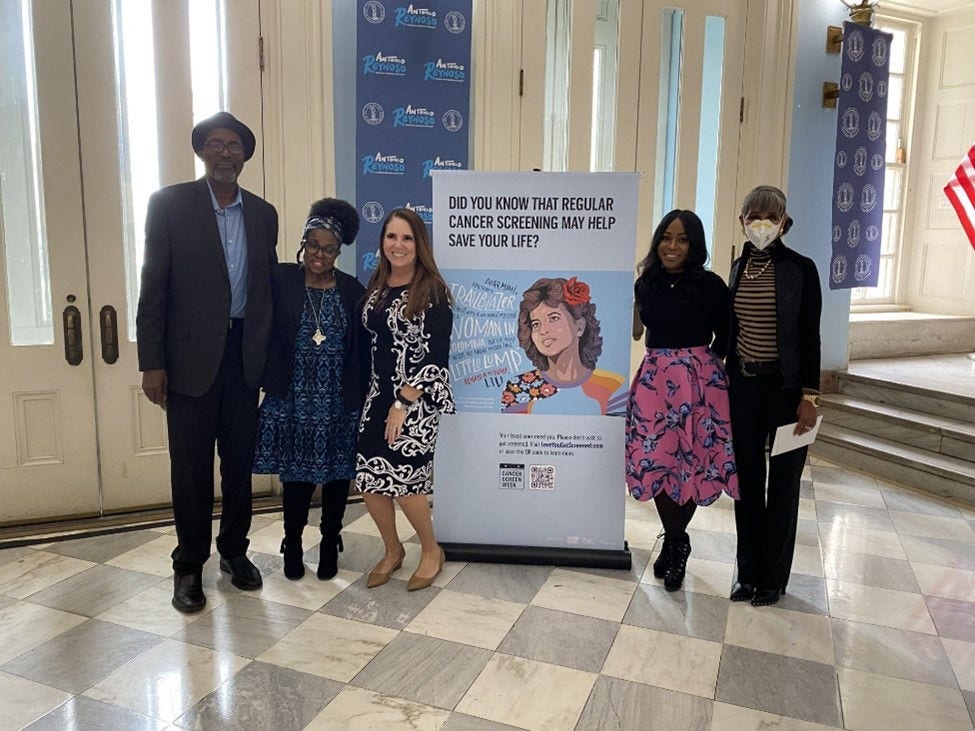 Five people gathered for a picture in the lobby of a building