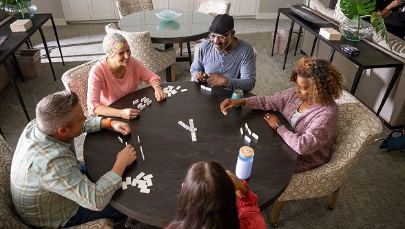 Group of five people playing a game at a table.