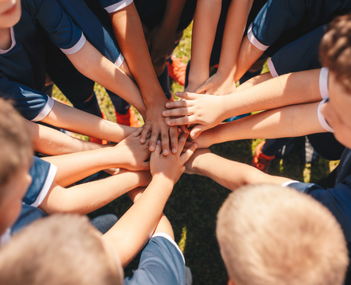 large group of children with hands huddled