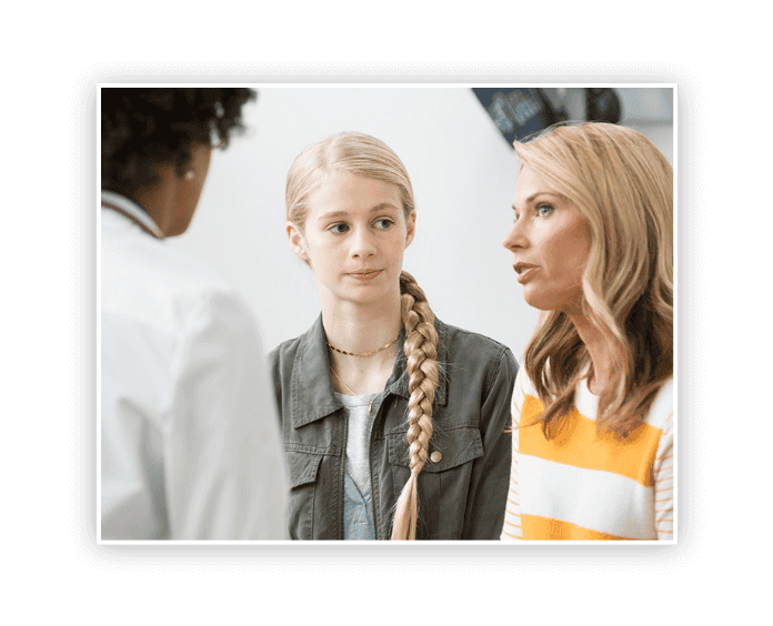 caucasian mother and daughter talking to doctor