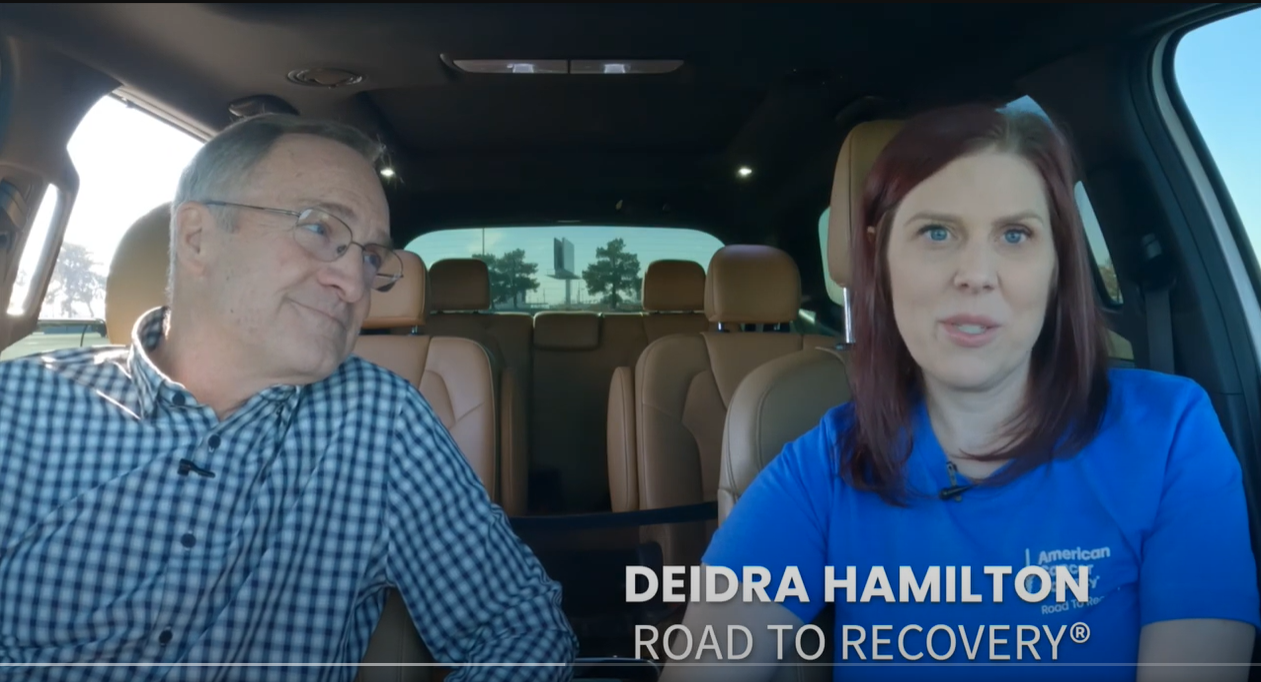 white woman and man siting in car talking to the camera