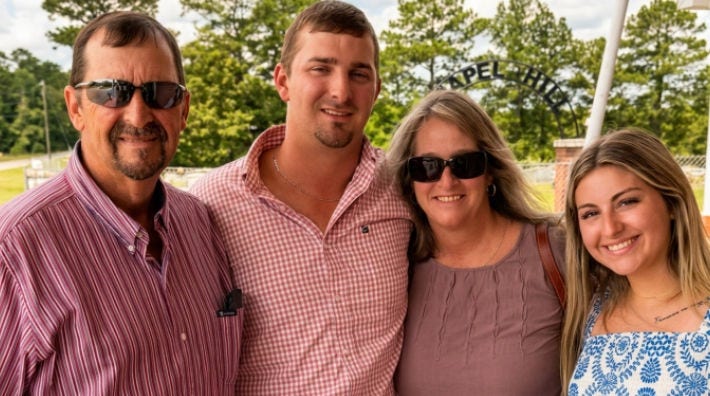 A family smiles for a photo outside of their church