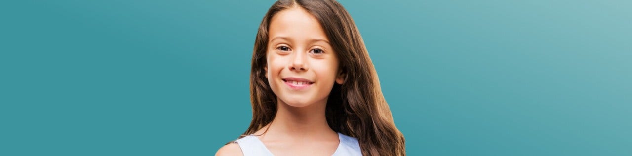 Caucasian girl with long hair smiling fin front of a teal background