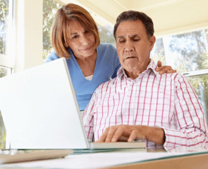A senior citizen couple using a laptop