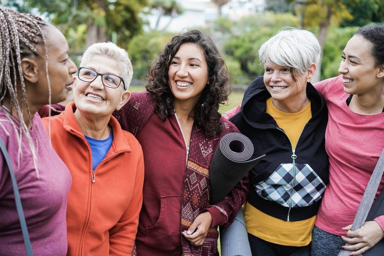 diverse group holding yoga mats outdoors