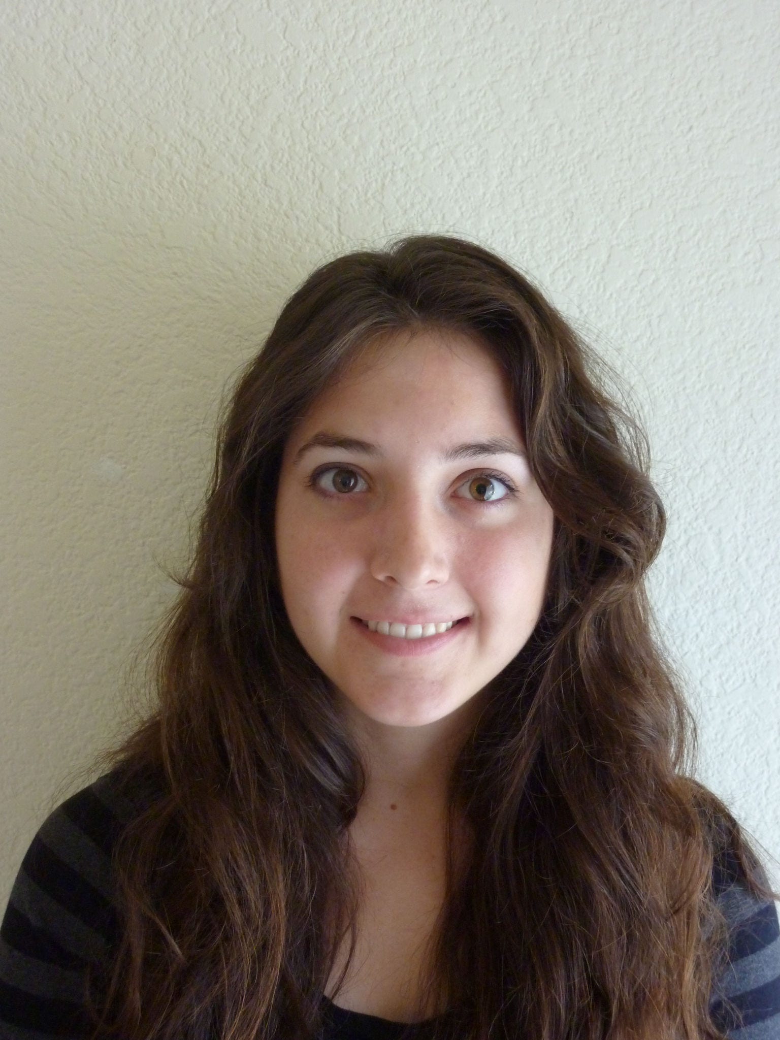 woman with long brown hair and brown eyes wearing blue striped shirt