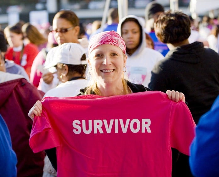woman in head scarf displays her survivor tee shirt  