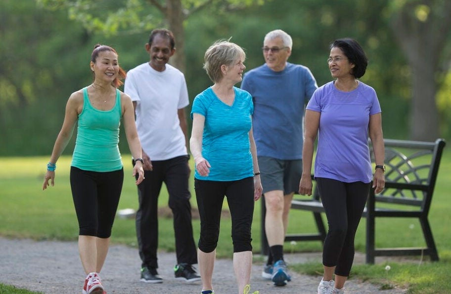 park with multiracial black white and asian people walking