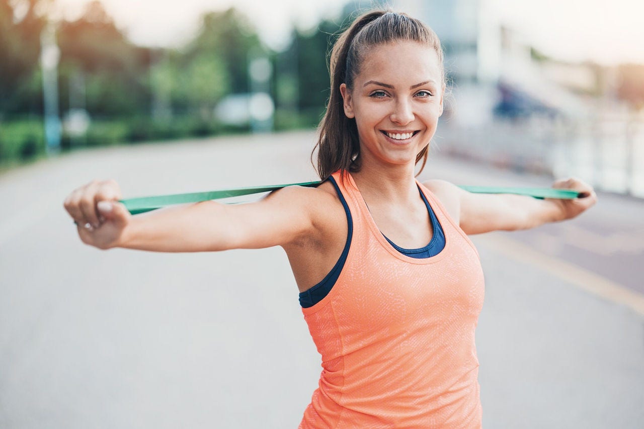 Woman stretches a resistance band across her shoulders
