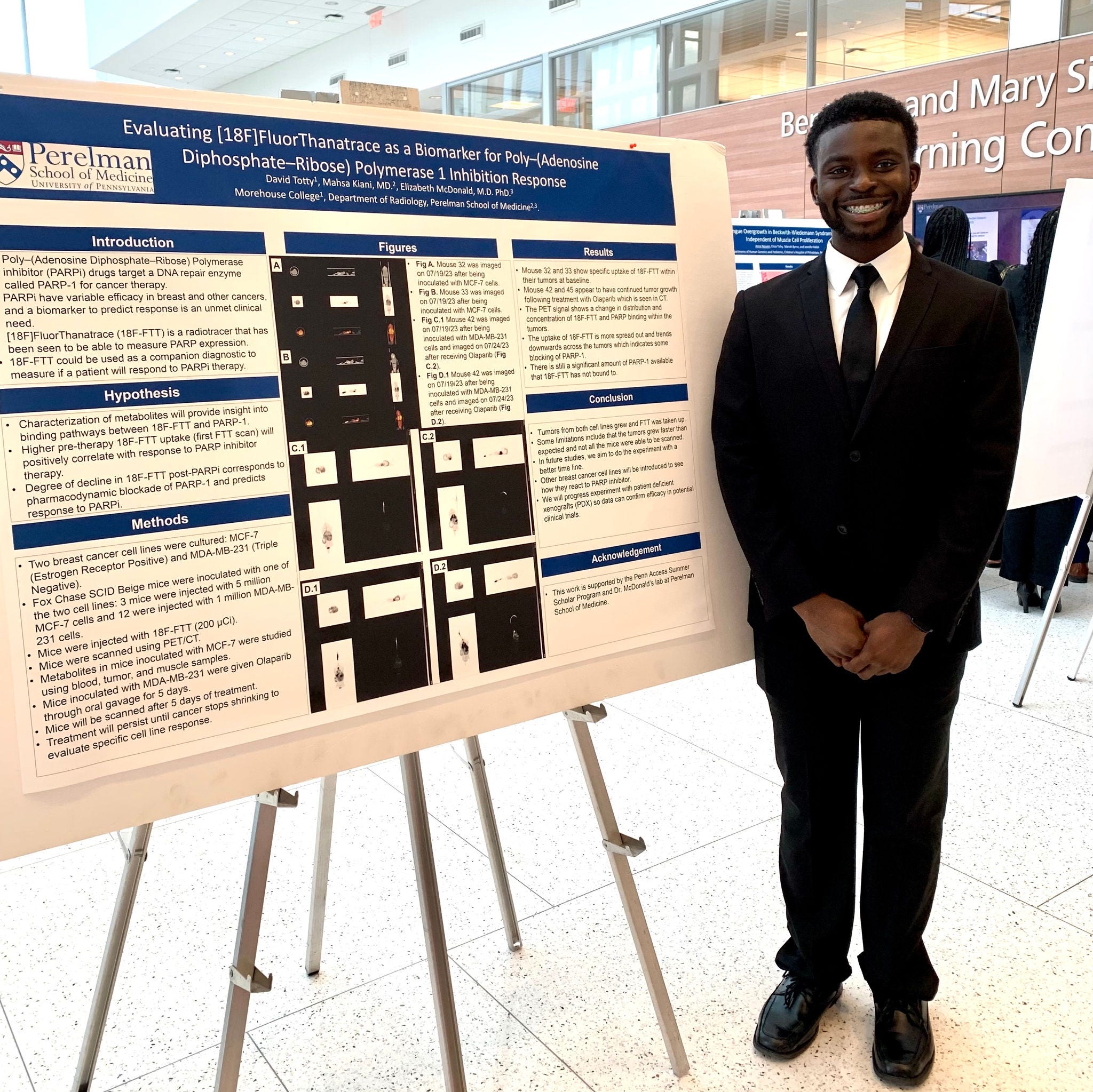 black male intern standing in front of poster board project