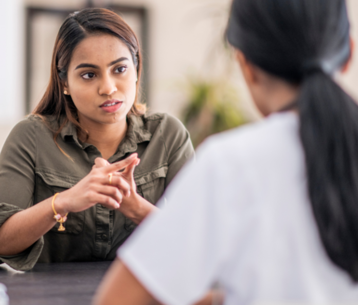 two women having discussion at a table